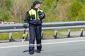 A woman police officer is on the roadway. Rear view