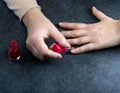 Woman polishing her nails on the gray background. Royalty Free Stock Photo