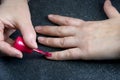 Woman polishing her nails on the gray background. Royalty Free Stock Photo