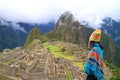 Woman in Poncho and Andean Hat Visiting the Amazing Ancient Inca Citadel of Machu Picchu, Peru