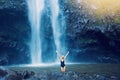 Woman in pool at base of large watefall Royalty Free Stock Photo