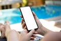 Woman by the pool holding phone with an isolated screen Royalty Free Stock Photo