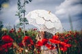 Woman in Poppy field with umbrella. Artistic interpretation