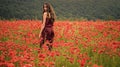 Woman in poppy flower field, harvest Beauty summer spring poppy seed. Drug and love intoxication, opium, medicinal.