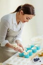 Woman poring dough in the decorative cupcake liners