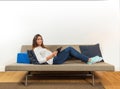 Woman with a portable tablet lying on a couch