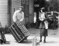 Woman and a porter carrying her trunk