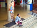 A woman porter sitting with mural background of a mother carrying a baby boy