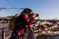 Woman in Porto bridge taking pictures with camera at sunset. Tourism in city Europe. travel Royalty Free Stock Photo