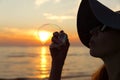 Woman portrait blowing soap bubbles at the beach. Beautiful suns Royalty Free Stock Photo