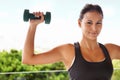 Woman, portrait and dumbbell exercise for weightlifting workout on balcony for gym fitness, sports or performance