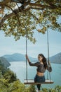 woman portrait enjoying nature from a hill top sitting on a swin Royalty Free Stock Photo