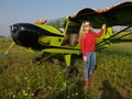 Woman portrait in front of an aircraft. Young beautiful woman with red jacket stand in front of older bomber aircraft Royalty Free Stock Photo