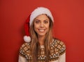 Woman, portrait and hat for Christmas in studio, relax and smile for festive season on red background. Female person Royalty Free Stock Photo