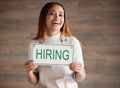 Woman, portrait and hiring sign for small business recruitment, career or job opportunity against a studio background