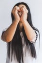 Woman portrait making heart shape with her hands. Selective focus on hands showing heart symbol