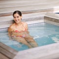 Woman, portrait and relax in jacuzzi at spa with happiness, vacation or holiday fun in summer with bikini. Tourist