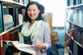 Woman, portrait and smile with book in library or studying for university education, scholarship or knowledge. Asian Royalty Free Stock Photo