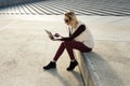 Woman portrait in summer. Girl is sitting outside an office and holding a tablet. Female with notebook Royalty Free Stock Photo