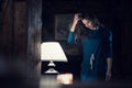 Woman portrait wearing casual dress smiling and looking down near lamp it living room at rural home indoor. Europe Alps Royalty Free Stock Photo