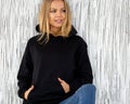 Woman poses in black hoodie