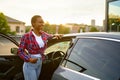 Woman poses at clean car, hand auto wash station