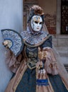 Woman poses in ornate, detailed costume, mask and hat, at the Doges Palace, St Mark`s Square during during Venice Carnival, Italy Royalty Free Stock Photo