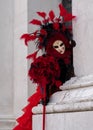 Woman poses in ornate, detailed costume, mask and hat outside San Giorgio Maggiore during Venice Carnival, Italy.