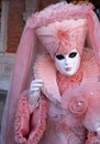 Woman poses in ornate, detailed costume, mask and hat, at the Doges Palace, St Mark`s Square during during Venice Carnival, Italy