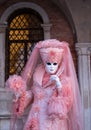 Woman poses in ornate, detailed costume, mask and hat, at the Doges Palace, St Mark`s Square during during Venice Carnival, Italy Royalty Free Stock Photo