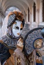 Woman poses in ornate, detailed costume, mask and hat, at the Doges Palace, St Mark`s Square during during Venice Carnival, Italy Royalty Free Stock Photo