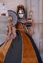 Woman poses in ornate, detailed costume, mask and hat, at the Doges Palace, St Mark`s Square during during Venice Carnival, Italy