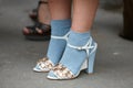 Woman poses for photographers with blue socks and white shoes with gems before Fendi fashion show, Milan