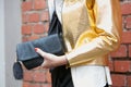 Woman poses for photographers with shiny golden jacket and black leather bag before Fendi fashion show, Milan