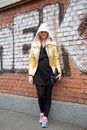 Woman poses for photographers with Stefania Marra golden jacket before Fendi fashion show, Milan Fashion Week