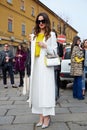 Woman poses for photographers with white coat, yellow shirt and coccinelle bag before Gucci fashion show,