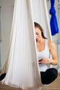 Woman posing in anti-gravity aerial yoga hammock. relax with phone