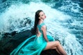 Woman posing on a beach with rocks