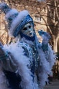 Woman posing in a blue winter costume and mask at the Venice carnival in Italy Royalty Free Stock Photo