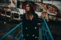 Woman posing on bridge against the background of an old rusty ship Royalty Free Stock Photo