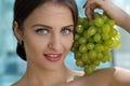 Woman posing with a bunch of grapes and smiling. Royalty Free Stock Photo