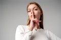 Woman Posing With Finger on Lips Hush Sign in Studio