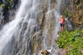 Woman posing in front of Dalfazer waterfall with her arms spread out as a Libra scale sign