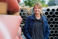 Woman posing next to stack pipes