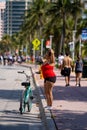 Woman posing for photo by her bike Miami Beach Ocean Drive
