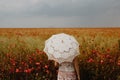 Woman posing in Poppies field with umbrella. Artistic interpretation