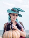 Woman posing with Pumpkin. Halloween Witch with in magic hat. Beautiful young surprised woman in witches hat and costume Royalty Free Stock Photo
