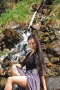 Woman posing on the rocks by the river