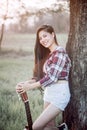 A woman posing with a trusty guitar in the garden Royalty Free Stock Photo