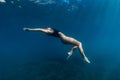 Woman posing underwater in blue ocean. Beautiful lady in bikini undewater Royalty Free Stock Photo